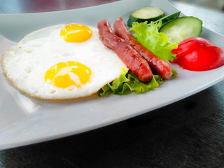 Morning breakfast with scrambled eggs sausages and vegetables