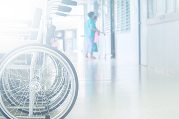 Empty wheelchair parked in hospital pathway blurred with patient walk in operation room