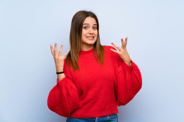 Young woman over isolated blue wall smiling a lot