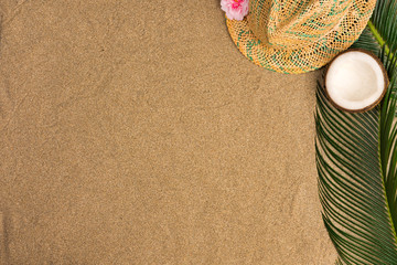Fototapeta na wymiar Space for text, beach theme on the sand background. Hat, coconut on the sand background. Top view.
