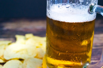 Fresh cold beer in a sweaty glass on a blurred background close-up