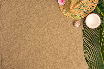Fototapeta na wymiar Space for text, beach theme on the sand background. Hat, coconut on the sand background. Top view.
