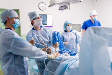 Arthroscope surgery. Orthopedic surgeons in teamwork in the operating room with modern arthroscopic...