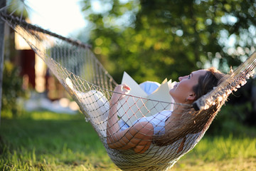 Beautiful young girl lying and reading a book
