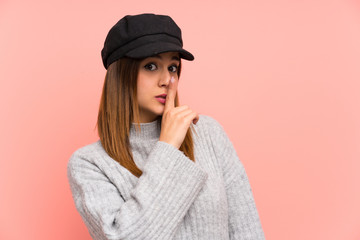 Fashion woman with hat over pink wall doing silence gesture