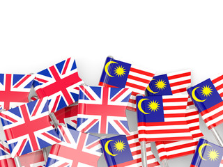 Pins with flags of UK and malaysia isolated on white.