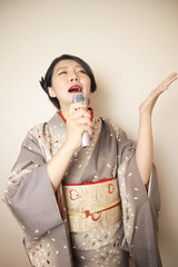 歌を歌う着物の日本人女性
