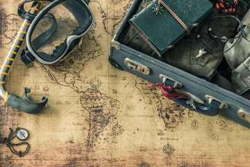 retro mask and snorkel with a suitcase, notebook, old map and travel equipment