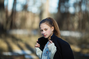 Teen girl posing for the camera walking in the spring Park.