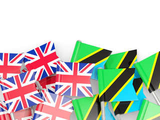 Pins with flags of UK and tanzania isolated on white.