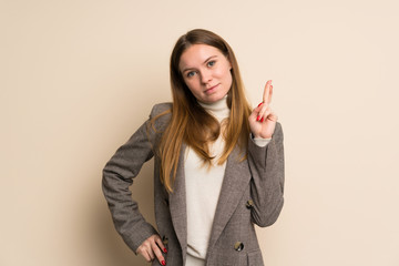 Young business woman with fingers crossing and wishing the best