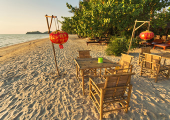 table and chairs on a tropical beach with sunset views