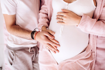 young couple expecting a baby. pregnant girl strokes belly. waiting for a miracle.
