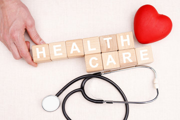 Young man hand arranging wood block stacking with text healthcare medical, insurance for your...