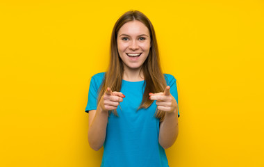 Young woman with blue shirt points finger at you