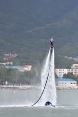A beautiful show on the water, a sports team flying on flyboards in the sea against the background...