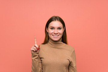 Young woman over colorful background pointing with the index finger a great idea