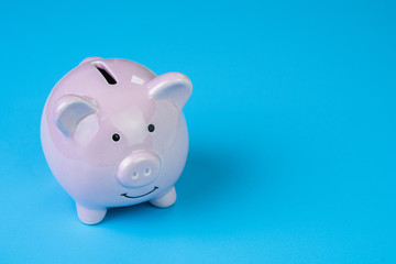Financial, savings, budget, cost or investment concept, white happy piggy bank on clean blue...