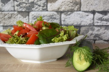 salad of vegetables and lettuce and beets in a white plate