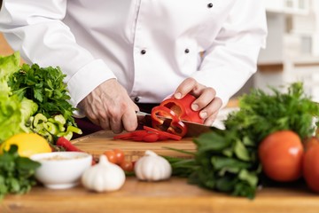 Chef cutting fresh and delicious vegetables for cooking.