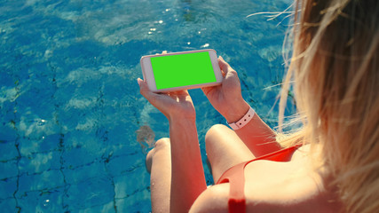Sexy blonde girl posing in the swimming pool .