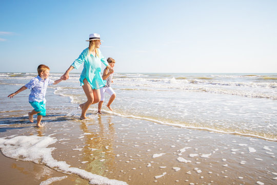 mother and her children playing on the beach