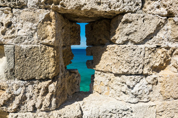 view of the sea through the loophole of the castle wall