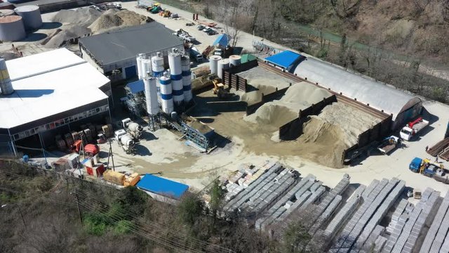 Aerial video shooting, Production of concrete and asphalt. Industrial shop. The view from the top. Shooting in hyperlapse mode. Fast movement. Truck. Concrete mixer. Base storage of sand and gravel.