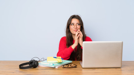 Teenager student girl studying in a table scheming something