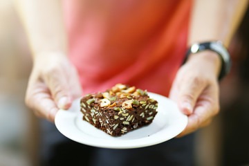 Dark cereals whole grain brownie on white plate.