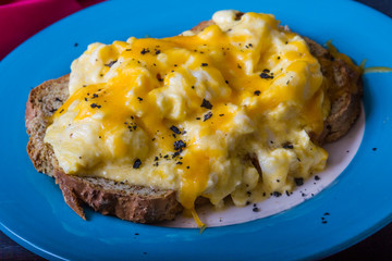 Scrambled eggs topped by grated cheese, with charcoal salt