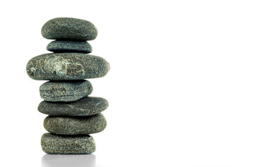 A pyramid of seven stones in balance is isolated on a white background.