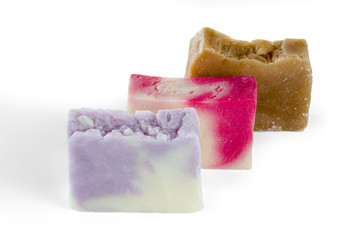 Three different handmade pieces of soap isolated on white background. Selective focus.