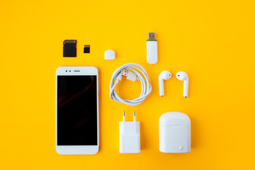 Mobile kit with smartphone, wireless headphones and chargers.