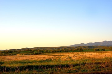 Fototapeta premium Rural area dawn landscape of fields and mountains near Saryozek, Almaty region