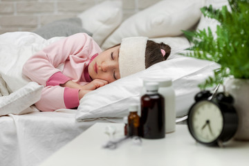 Sick little child girl lying in bed with thermometer. Cold flu season