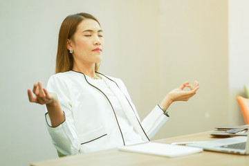 close up secretary woman closed eyes and doing yoga lotus pattern on hand for relax fater work hard...