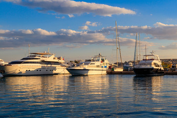 Fototapeta premium White yachts in the sea harbor of Hurghada, Egypt. Port with tourist boats on the Red Sea