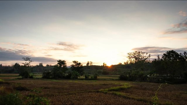 Morning sunrise with clouds moving In the empty field, the time lapse of the dry season