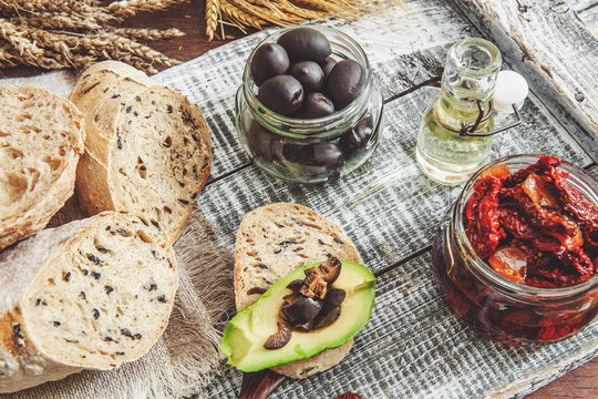 Homemade bread with olives with sun-dried tomatoes, avocado and olive oil