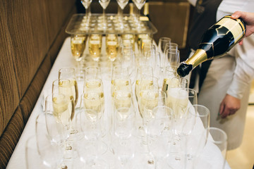 The waiter pours champagne to a party. glasses of champagne.