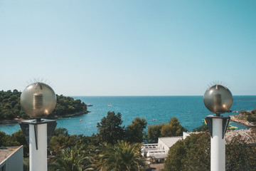 Round glass lanterns on the background of the sea coast. Shoreline lighting with energy-saving lamps