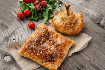 Fast food eastern nations. Samsa and chicken drumstick on a platter with cilantro and vegetables.