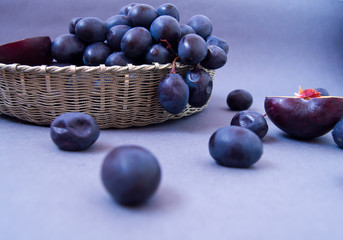 black grapes in a silver basket on a gray background