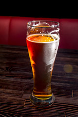 Light beer in a glass on a wooden table