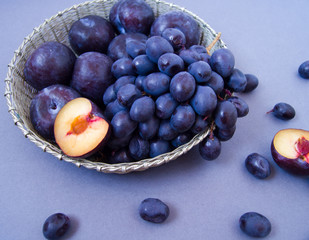 grapes and plums in a silver bowl