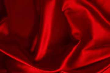 Red silk or satin luxury fabric texture can use as abstract background. Top view.