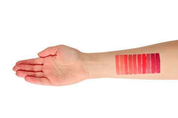 Lipstick swatches on woman hand isolated on white background.