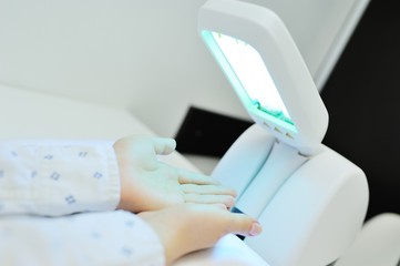 hands of a patient with psoriasis close-up under an ultraviolet lamp. Light therapy, phototherapy