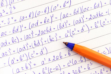 Math formulas and orange ballpoint pen.
